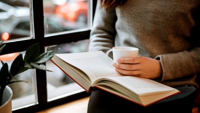 窓際で本を読む女性