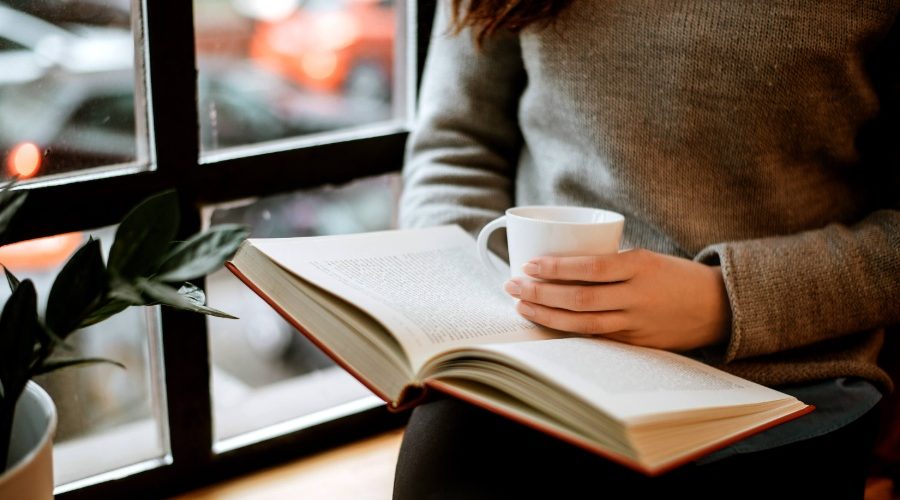 窓際で本を読む女性